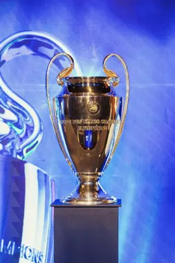 Puchar Ligi Mistrzów UEFA na postumencie, na niebieskim tle.